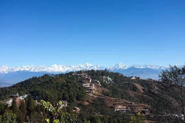 The Kathmandu Valley with the Himalayan range rising in the distance, afternoon light.